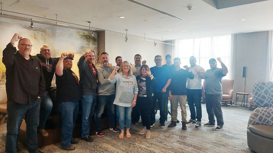 A group photo indoors people with a fist in the air.