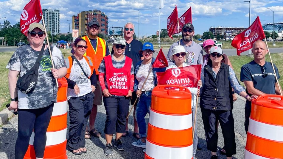 Unifor members picketing Casino Woodbine Unifor members standing behind large orange traffic cones on one of the roads into Casino Woodbine