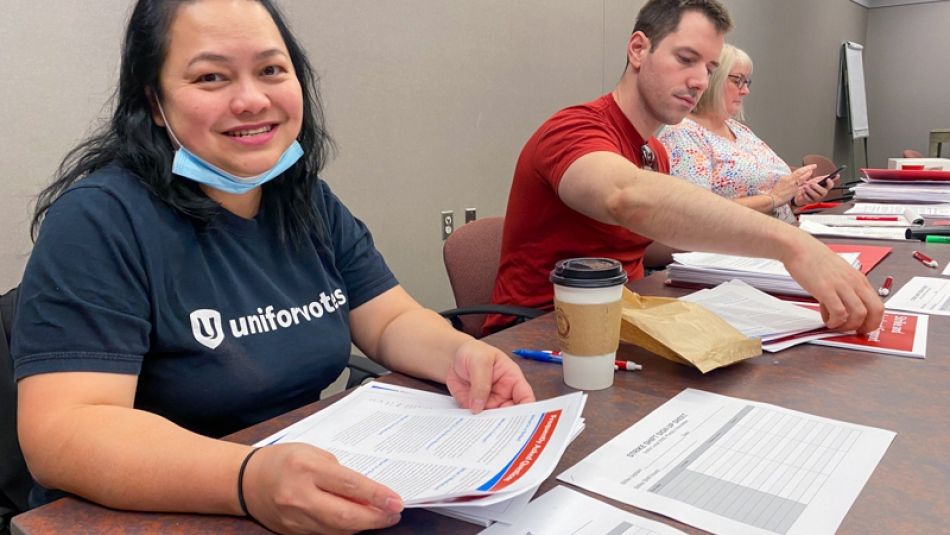 Purdy's workers at strike vote Two people seated at a registration table, one person is smiling and looking at camera