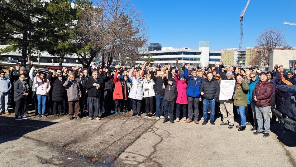 Crowd gathered around a truck for a photo.