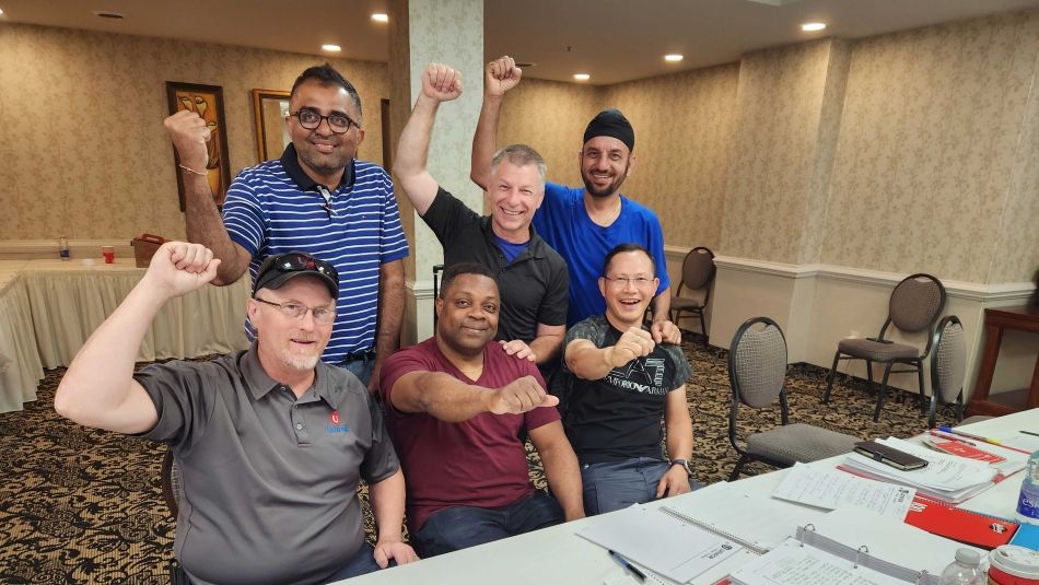 Woodbridge Foam Bargaining Committee members posing with their fists in the air smiling