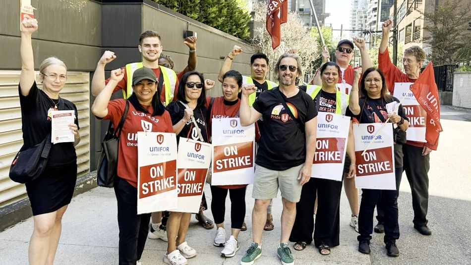 Residence Inn workers A dozen people outside with "On Strike" placards and fists in the air.
