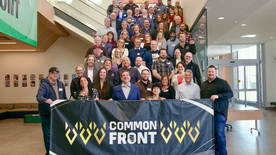 Un groupe de dizaines de dirigeants syndicaux a posé sur un escalier avec une banderole portant l'inscription "Common Front" (Front commun).