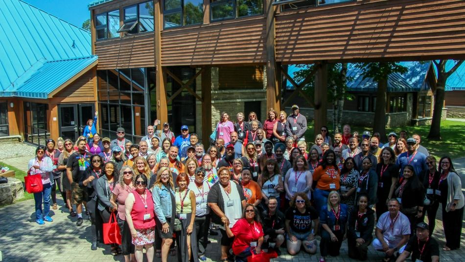 A large group photo outside the Unifor FEC classroom building in the sunshine.