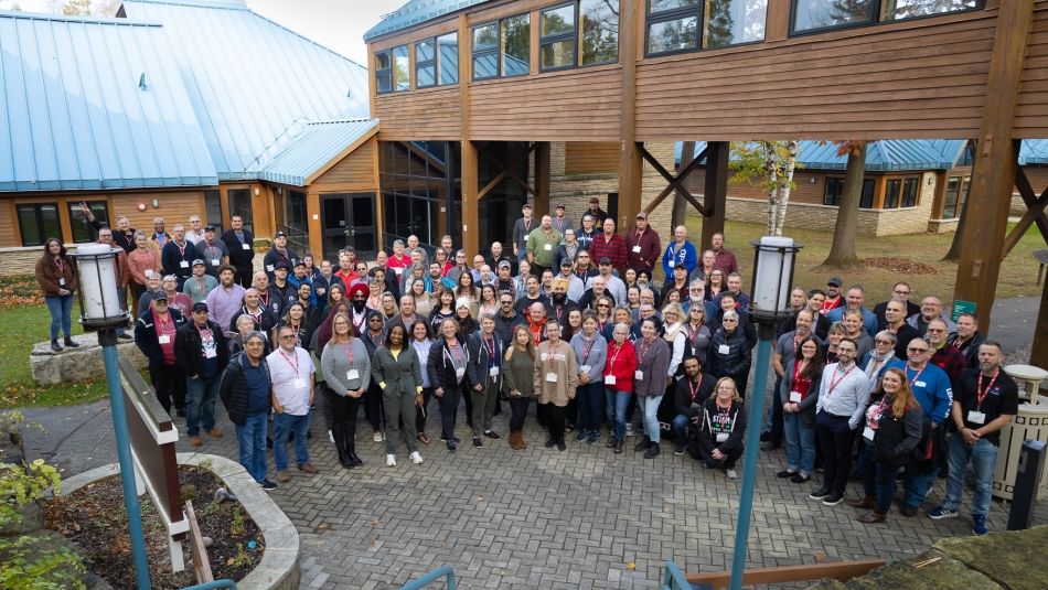 A crowd posing for a group pic outdoors