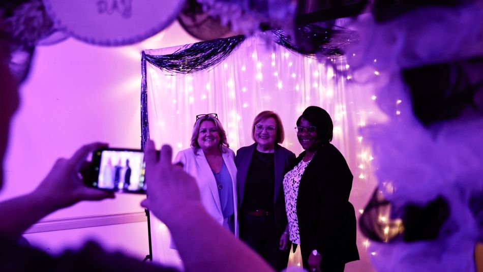La présidente nationale d'Unifor, Lana Payne, pose pour une photo sous une arche de ballons avec deux consœurs d'Unifor.