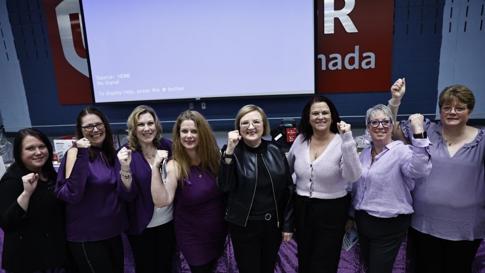 La présidente nationale d'Unifor, Lana Payne, avec un groupe de sœurs d'Unifor qui lèvent le poing en signe de solidarité.