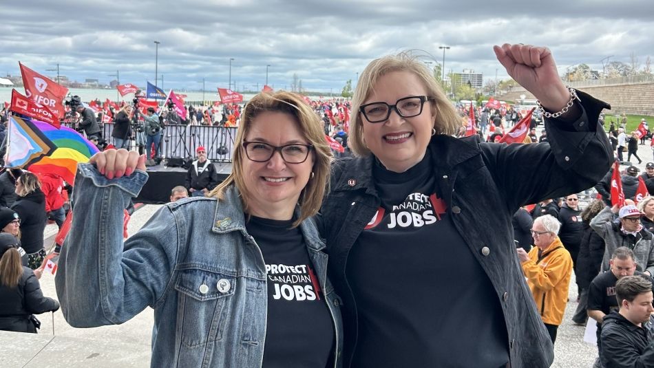 Two women embracing wearing Unifor Protect Canadian Jobs shirts