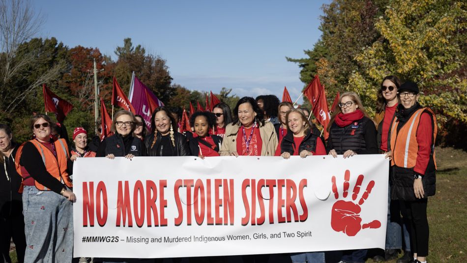 A crowd walking behind a banner that reads; no more stolen sisters