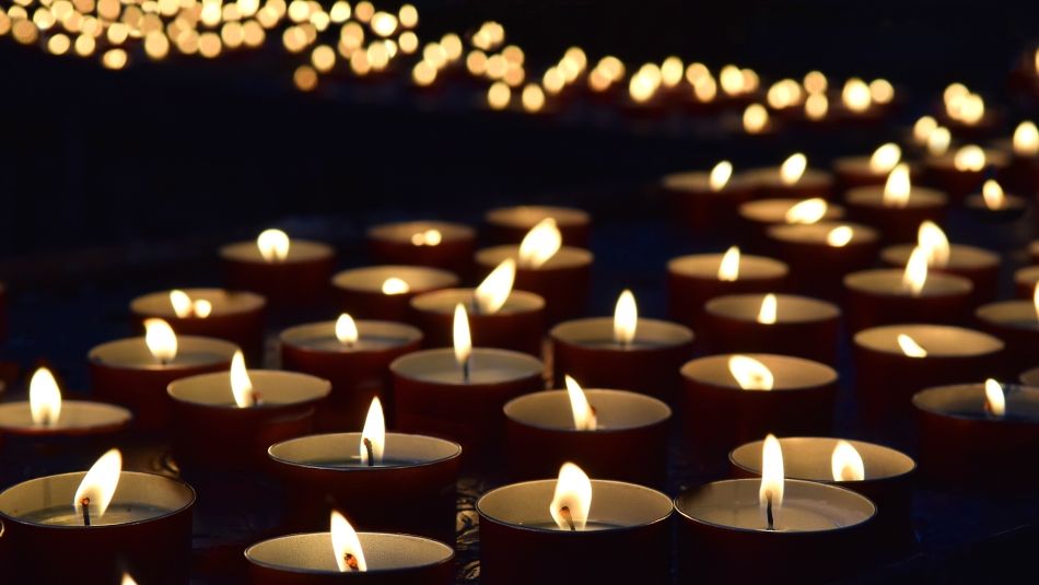 tea light candles lit a row in darkness