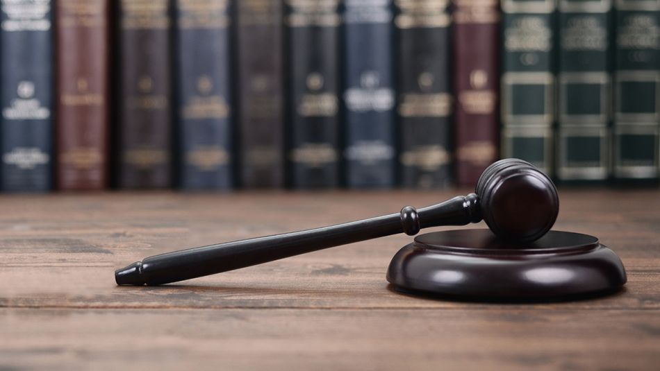 Gavel laying on its side in front of row of books