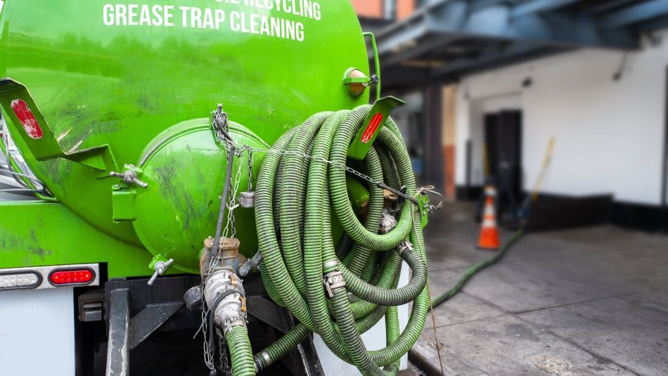 A green coloured grease removal truck.