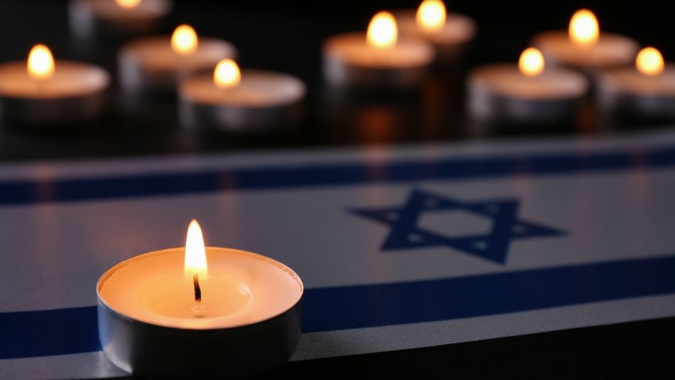 Tea light candles surround a Israeli flag