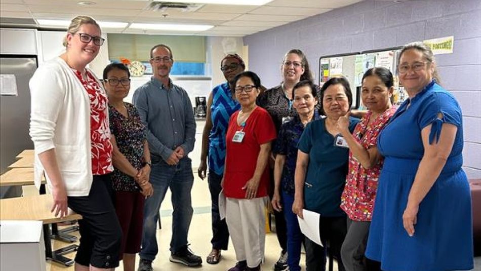 A group of workers in a break room posing smiling