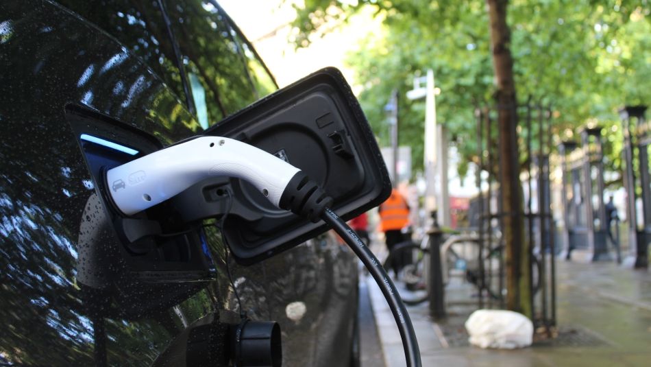 An electric vehicle is charging at a station.