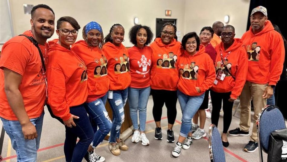 Ten people wearing orange shirts 
