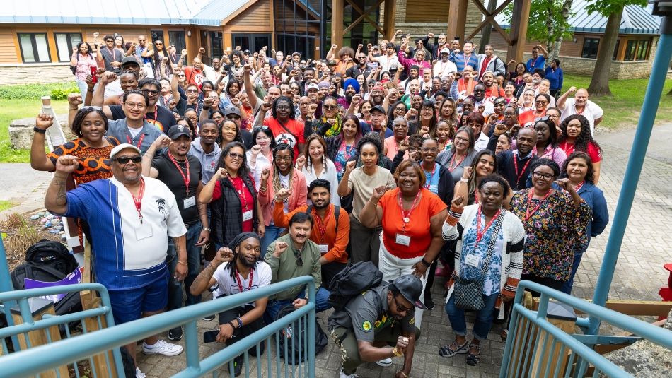 A large BIWOC group posing outside at the bottom of a staircase