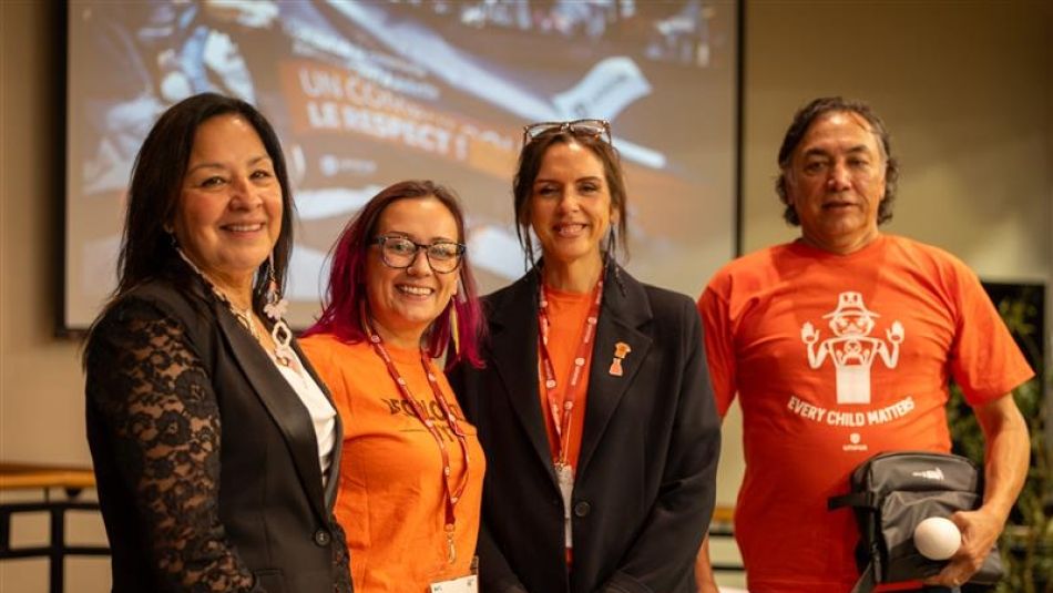 Four people wearing orange shirts