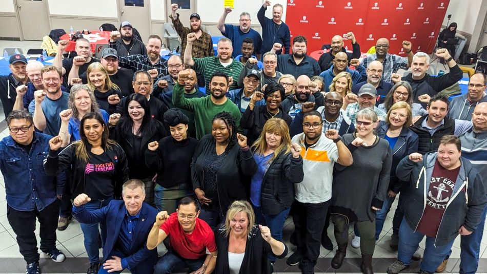 Large group posing with fists in the air