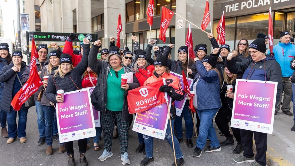 Unifor members and allies from the Health Care sector holding flags and posters in support of fair wages.