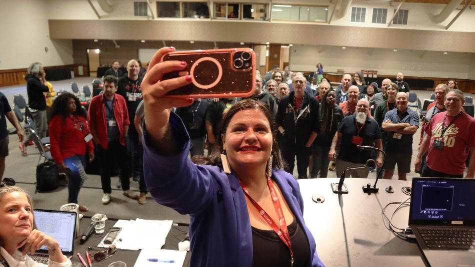 une femme prenant un selfie depuis une scène devant un grand groupe