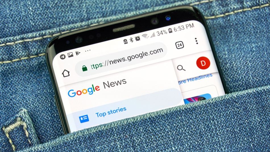 Google News on a phone displaying “top stories” in a jean pocket.