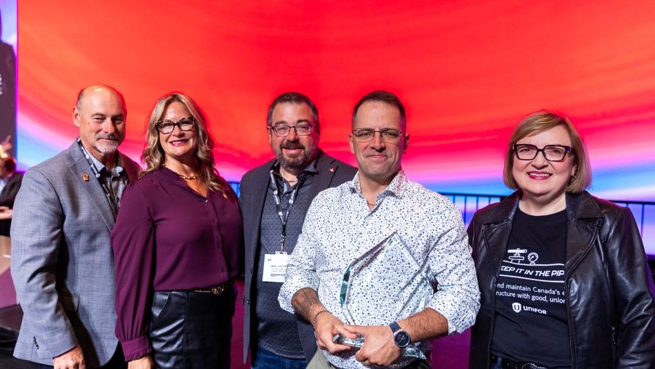 Robert Girard holds his Bud Jimmerfield award while standing with Unifor National leadership