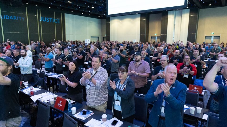 A crowd of people standing and applauding.