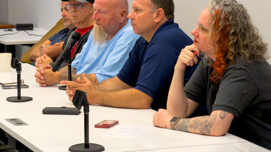 Four people sitting at a table with mics