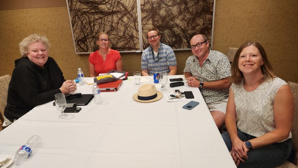 Un groupe de personnes assises à une table.