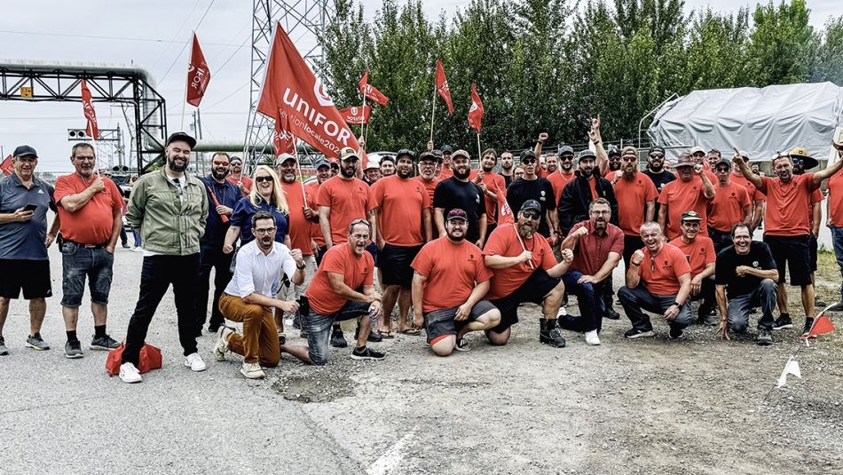Grand groupe de personnes, certains poings en l'air, d'autres tenant des drapeaux.