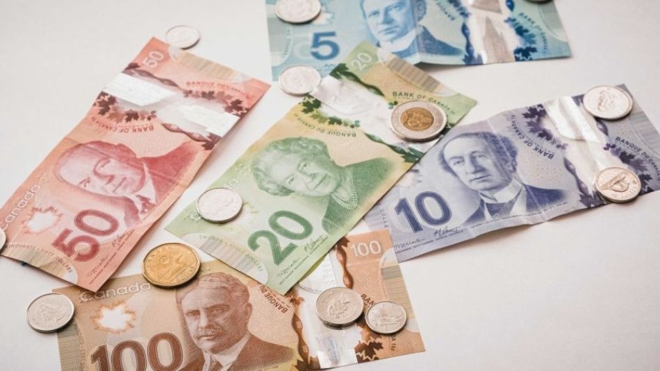 Les billets canadiens disposés avec les pièces de monnaie