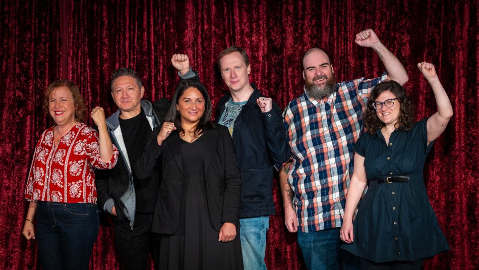 A group on a stage with their fists raised