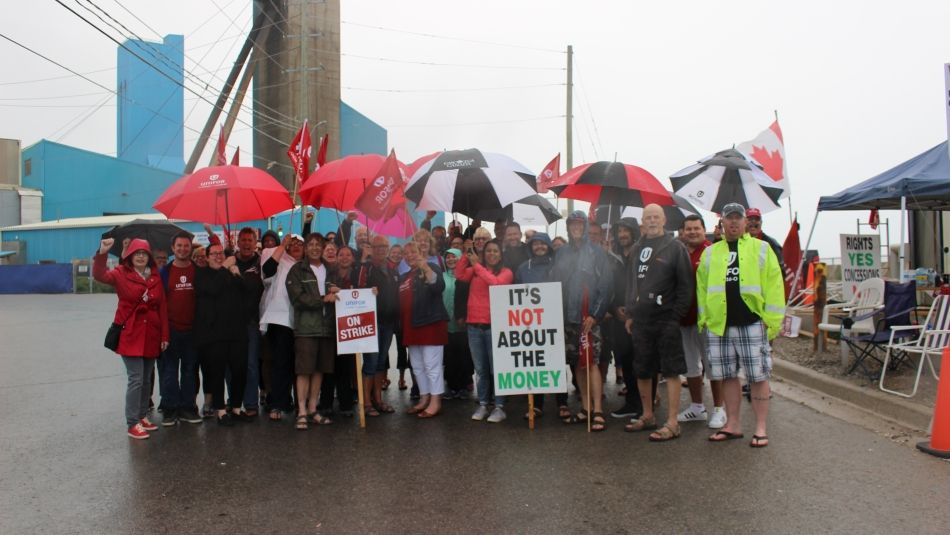 members on the picket line in the rain standing for a group photo