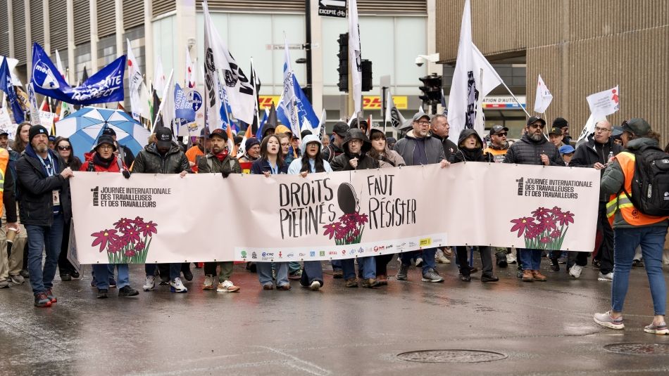 A large group behind a banner holding flags
