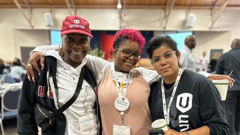 Three women of colour posing together.