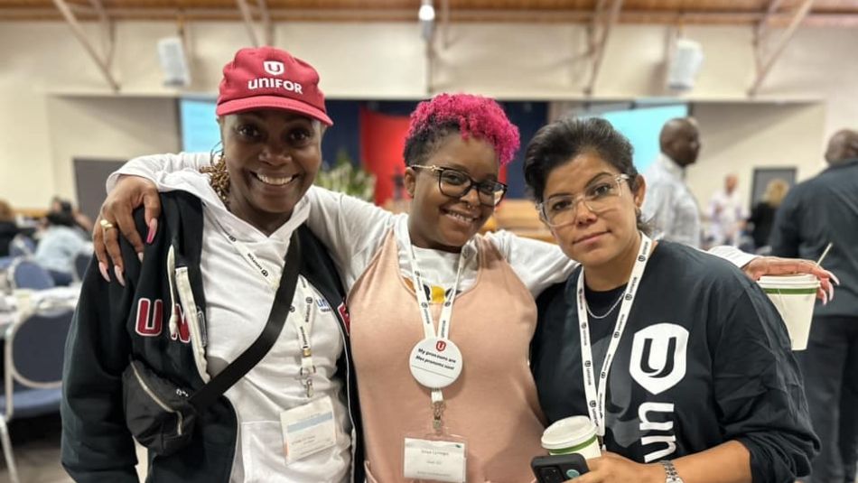 Three women of colour posing together.