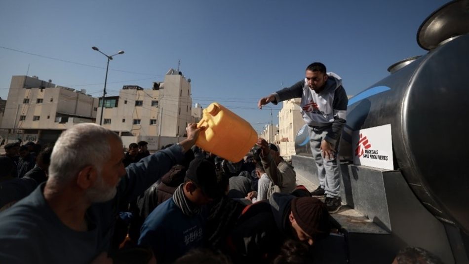 A man handing a cantainer of water to a crowd