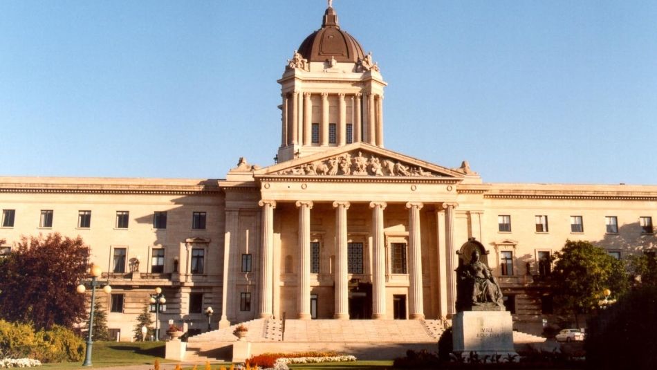 « Édifice de l’Assemblée législative du Manitoba avec un parterre de fleurs au premier plan. »