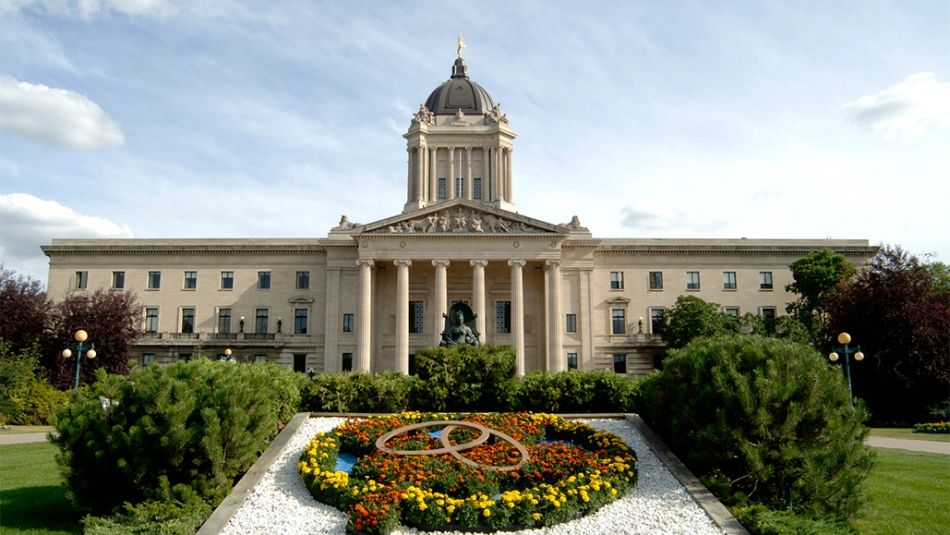 « Assemblée législative du Manitoba avec un parterre de fleurs à l’avant-plan. »