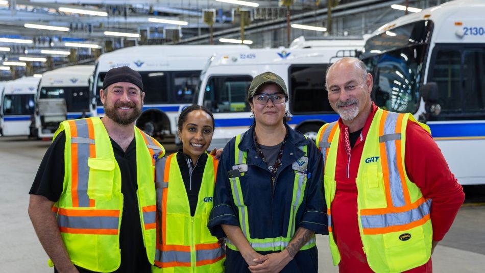 Unifor National Secretary Treasurer and Ontario Regional Director Samia Hashi pose for photo at bus depot with transportation workers. 