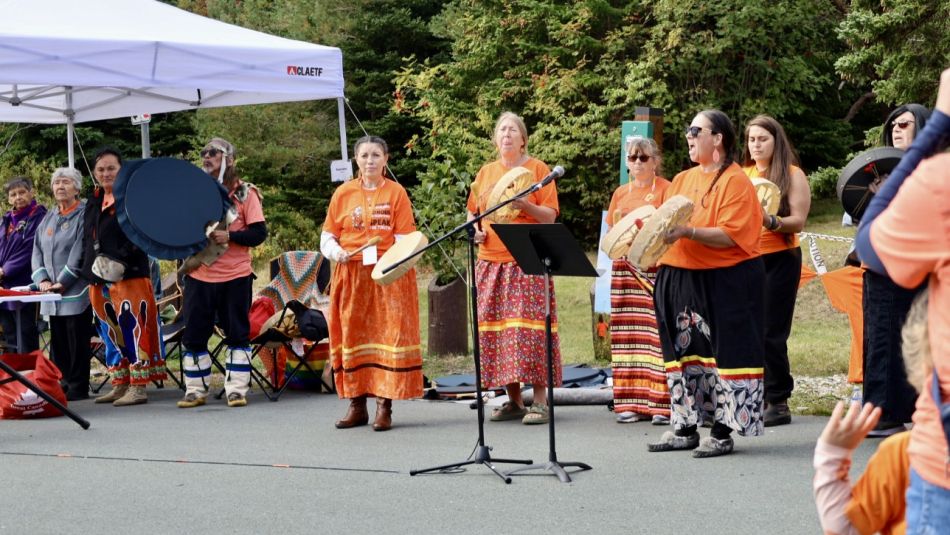 A music group on a stage in orange shirts