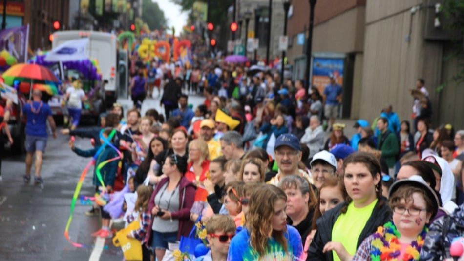 A happy crowd watches a recent pride parade. 