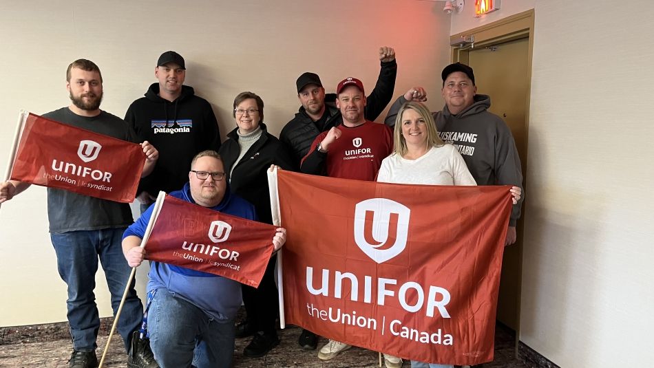 A group of people holding up unifor flags