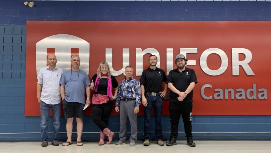 Local 222 Bargaining committee members stand in front of the Local 222 union hall banner. 