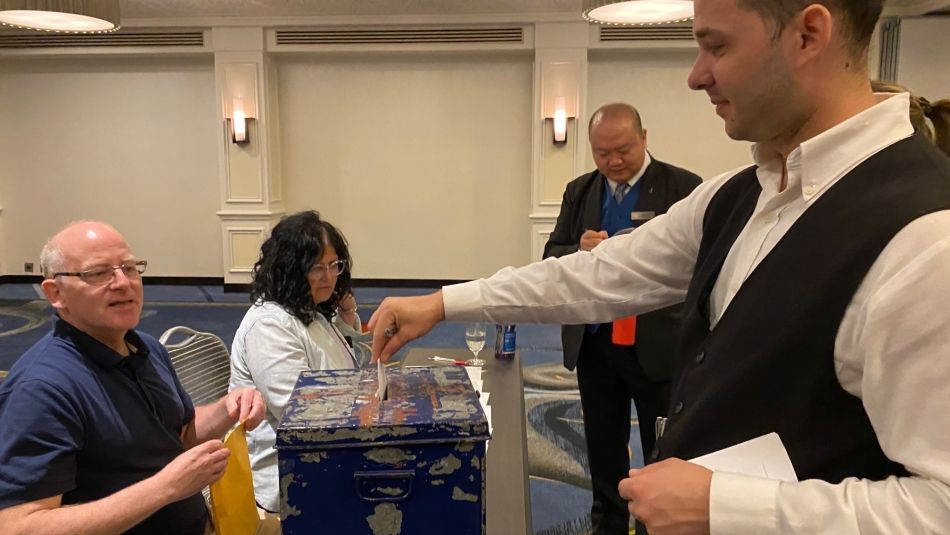 Unifor members dropping ballots into a ballot box at the Fairmont Hotel Vancouver