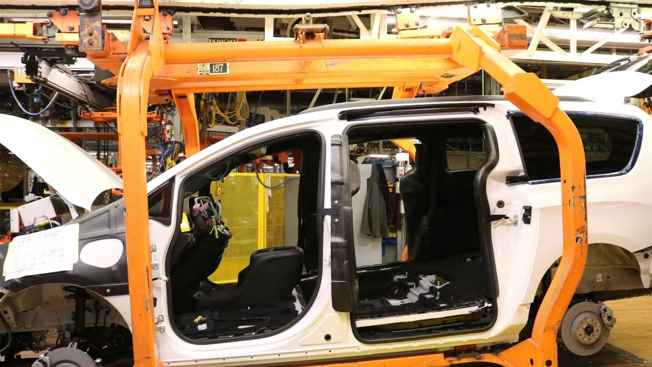 A car being built on an assembly line without doors