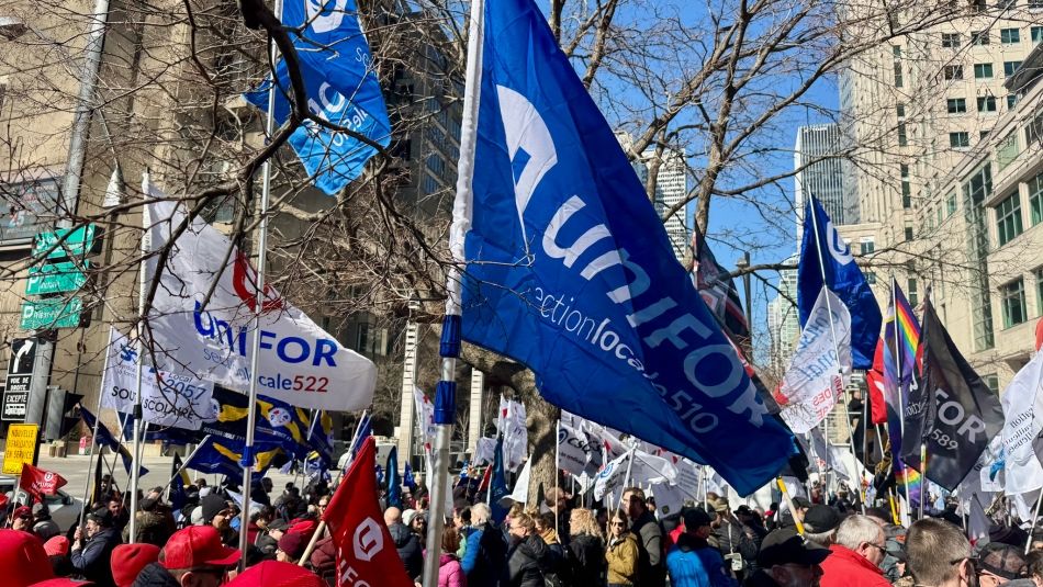 Unifor flags and a crowd of people marching