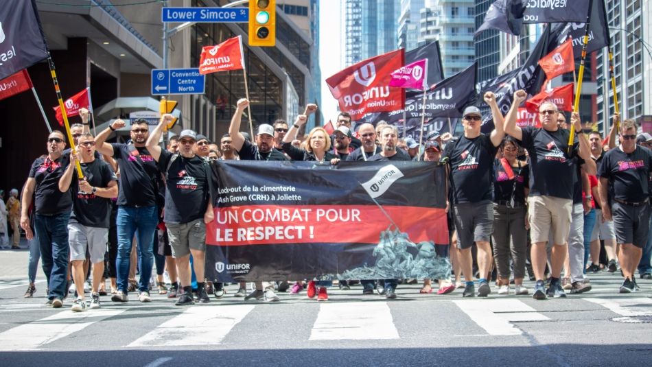 Les dirigeants et les membres d'Unifor défilent pour les travailleurs en grève à Toronto.