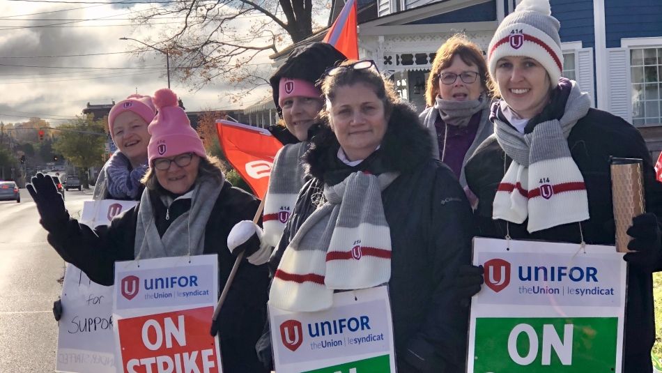 Striking women’s shelter workers smile on the picket line.